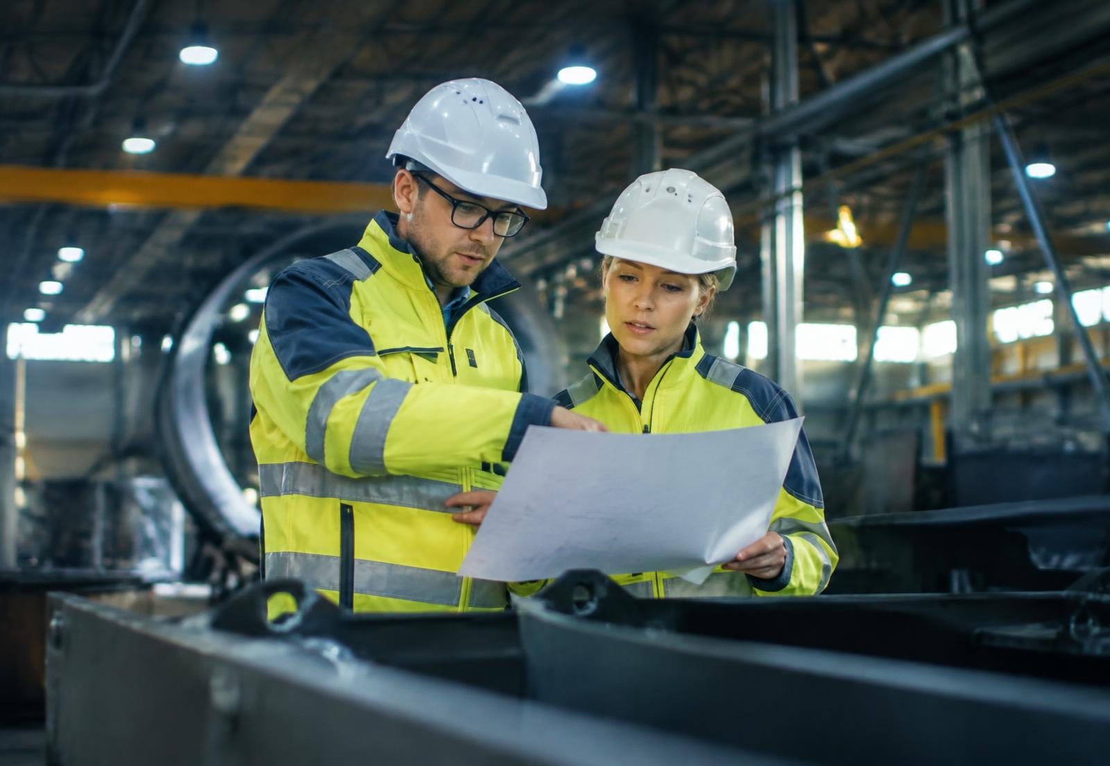 Engineers reviewing plans inside a manufacturing plant